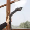 A hand holding a steam cleaner and cleaning a window. Podgląd zdjęcia produktu