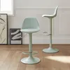 Two adjustable bar stools in a light green color are shown in a room with wooden flooring and white paneled walls. Anteprima dell’immagine prodotto