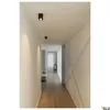 A modern hallway with wooden floors and white walls, illuminated by ceiling lights. Produktbild-Vorschau