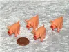 Four small plastic pigs and a coin on a textured surface. Produktbild-Vorschau
