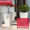 Two white planters with plants in them, placed outdoors on a patio. Podgląd zdjęcia produktu