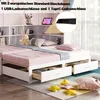 A white bed with pink bedding and storage drawers, featuring a built-in shelf unit with decorative items and a tablet. A close-up inset shows a power outlet with USB ports. Produktbild-Vorschau