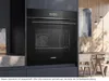 A modern kitchen with a built-in Siemens oven, set against a dining area with wooden walls and furniture. Produktbild-Vorschau