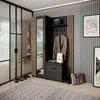A modern entryway with a black and oak artisan wardrobe set, featuring a mirror, coat hooks, and storage. The room also includes a glass partition, a rug, and artwork on the wall. Produktbild-Vorschau