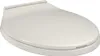 A light gray oval toilet seat with a soft-close lid is shown from a slightly elevated side angle against a white background. Podgląd zdjęcia produktu