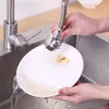 A person is washing a plate under a faucet with a spray attachment in a kitchen sink. Náhľad obrázku produktu
