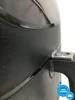 A close-up shot of the side of a black air fryer, focusing on the handle attachment and the textured surface. Produktbild-Vorschau