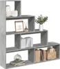 A concrete gray, multi-tiered bookshelf filled with decorative items and books, presented against a white background. Náhled obrázku produktu