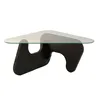 A modern coffee table with a glass top and a dark, sculptural base. Produktbild-Vorschau