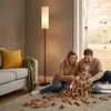 A family is playing with wooden blocks on the floor in a living room with a large window showing autumn leaves outside. Náhľad obrázku produktu