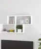 A white wall-mounted shelf unit with various decorative items. Voir les images du produit