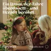 A young girl and an older woman are sitting in front of a decorated Christmas tree. Produktbild-Vorschau
