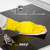 A hand wearing a yellow glove is cleaning a black induction cooktop with a pink cloth. The brand logo and product name are visible at the top, and the word 'easy!' is at the bottom. Produktbild-Vorschau
