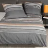 A neatly made bed with striped bedding and pillows. Produktbild-Vorschau