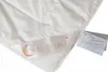 A close-up of a white duvet with a brand label and a product tag. Produktbild-Vorschau