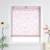 A pink patterned roller blind hanging in a white window frame. Produktbild-Vorschau