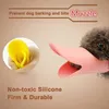 A dog wearing a pink duck-shaped muzzle, with a yellow object in the background and text describing the product's features. Produktbild-Vorschau