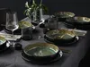 A table setting with plates, bowls, glasses, and cutlery, arranged on a gray tablecloth. Produktbild-Vorschau