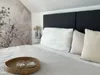 A close-up view of a bed with pillows and a decorative tray with candles. Produktbild-Vorschau