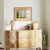 A rattan mirror hangs above a wooden dresser in a hallway, with a lamp, plant, and basket on top. Podgląd zdjęcia produktu