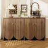A wooden sideboard with a ribbed texture and scalloped doors, decorated with various items on top and set against a wall with blinds. Podgląd zdjęcia produktu
