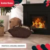 A dark brown wicker basket filled with firewood is placed in front of a black fireplace with a fire burning inside. There are also other wicker baskets and plants in the background. Voir les images du produit