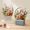 Two 3D wooden flower baskets with intricate floral arrangements are displayed on a wooden surface, with a stack of books under the left basket. Podgląd zdjęcia produktu