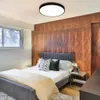A bedroom with a bed, wooden wall paneling, and a ceiling light. Produktbild-Vorschau