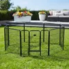 A black metal pet playpen is set up on a green lawn in a backyard setting. In the background, there are flower pots with colorful flowers, a patio, and outdoor furniture. Anteprima dell’immagine prodotto