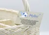 A close-up of a white wicker basket with a tag attached. Produktbild-Vorschau