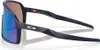 A pair of dark blue Oakley Sutro S sport sunglasses with blue and brown lenses, shown from a side angle on a white background. Náhled obrázku produktu