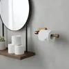 A bathroom setting with a toilet paper holder and rolls on a shelf. Produktbild-Vorschau