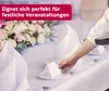 A hand places a name card on a table setting with a floral arrangement in the background. Produktbild-Vorschau