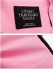 A close-up view of a pink fabric with a black label attached. Náhled obrázku produktu