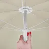 A close-up view of the mechanism for opening and closing a beach umbrella, with a hand pressing a red button. Voir les images du produit