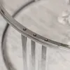 Close-up of a round coffee table with a chrome frame and glass top. Náhled obrázku produktu