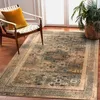 A rug is placed on a wooden floor next to a chair and a plant. Voir les images du produit