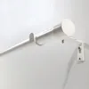 Close-up of a white curtain rod mounted on a white wall. Voir les images du produit
