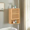 A wooden bathroom cabinet mounted on a wall above a bathtub. Produktbild-Vorschau