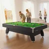 Four people are playing pool in a well-lit living room with large windows. Podgląd zdjęcia produktu