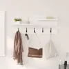 A wall-mounted shelf and coat rack with various items displayed. Voir les images du produit