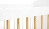 A close-up view of the top railing and wooden slats of a white crib. Produktbild-Vorschau