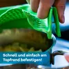 A hand is holding a green silicone strainer over a pot of food. Produktbild-Vorschau