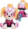 A plush toy of the character Skye from Paw Patrol, dressed in a superhero costume, is shown sitting. A second Skye plush toy is visible in the background, also sitting. A product tag is attached to the front plush toy. Anteprima dell’immagine prodotto