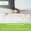 A person peeking from under a white duvet with pillows in the background. Produktbild-Vorschau