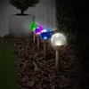 A row of solar garden lights with colored glass spheres are illuminating a garden bed at night. Produktbild-Vorschau