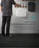 A person holding a white storage bag with a rug inside, next to a coat rack with a backpack. Produktbild-Vorschau