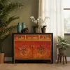 A vintage-style oriental sideboard with decorative elements, placed in a room with plants and a window with curtains. Produktbild-Vorschau