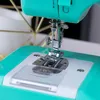 A close-up view of the needle and presser foot of a sewing machine. Produktbild-Vorschau