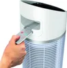 A hand is inserting a remote control into a slot on an air purifier. Voir les images du produit
